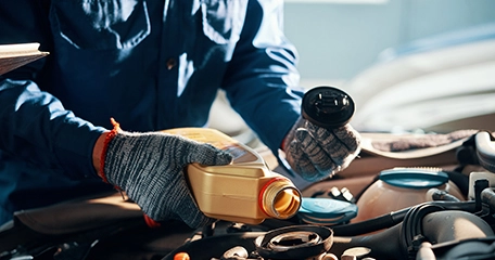 mechanic adding oil to engen